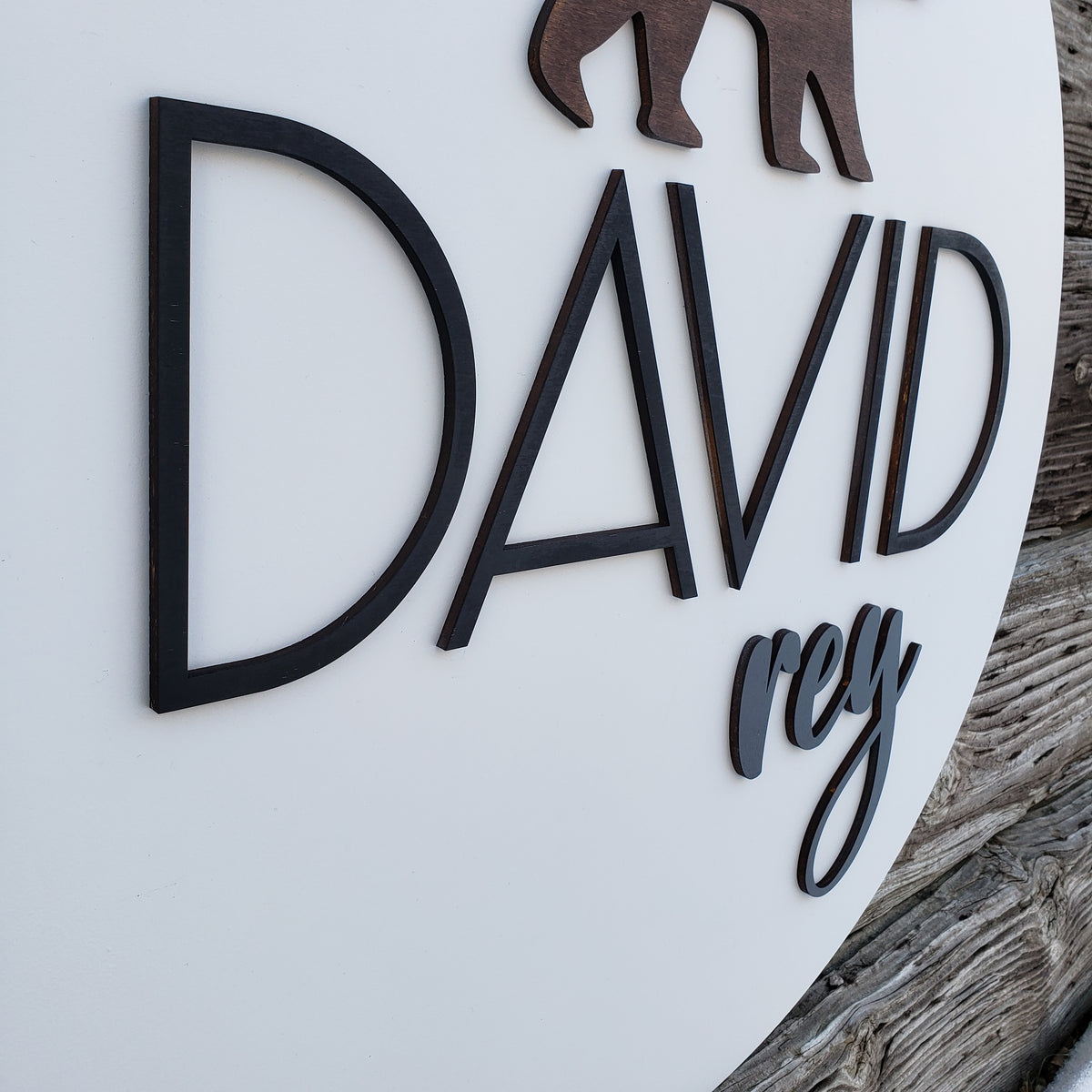 Close-up of raised 3D lettering and bear detail on wooden nursery sign