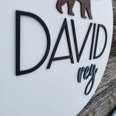 Close-up of raised 3D lettering and bear detail on wooden nursery sign