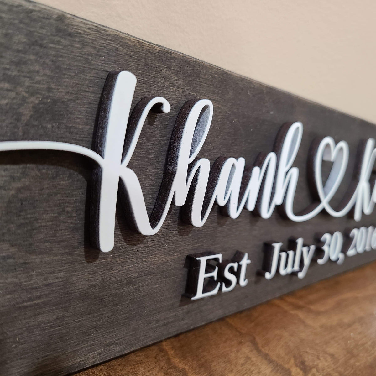 Close-up of raised 3D lettering on personalized wooden couple sign