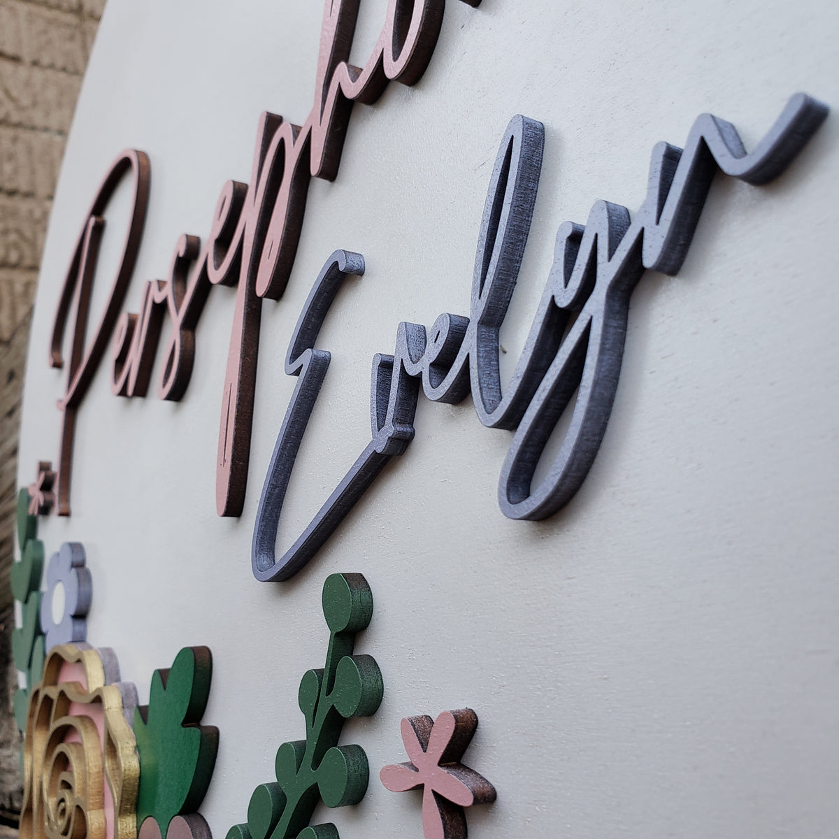 Close-up of raised 3D lettering and flowers on personalized nursery sign