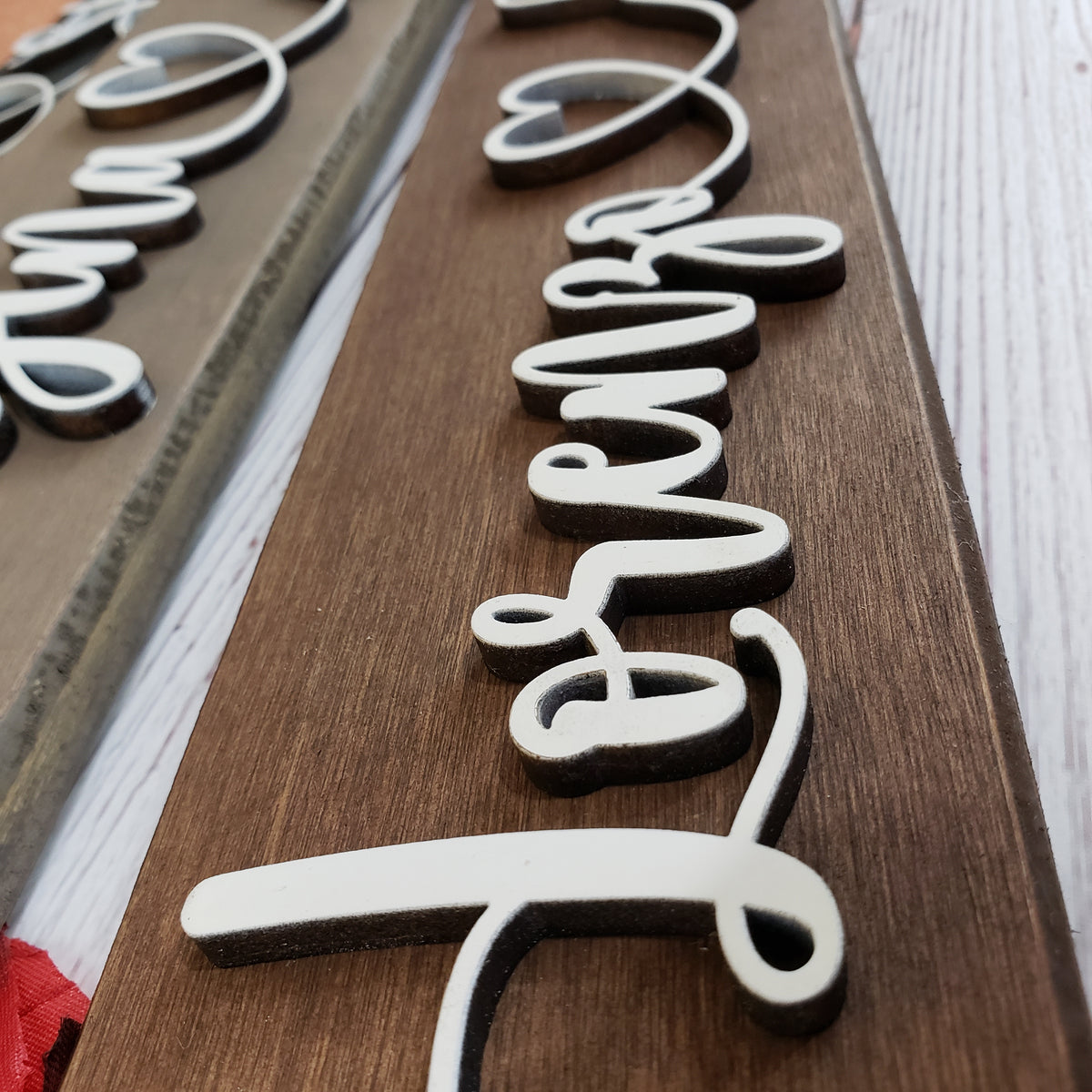 Close-up of raised 3D lettering on a personalized wooden couple sign